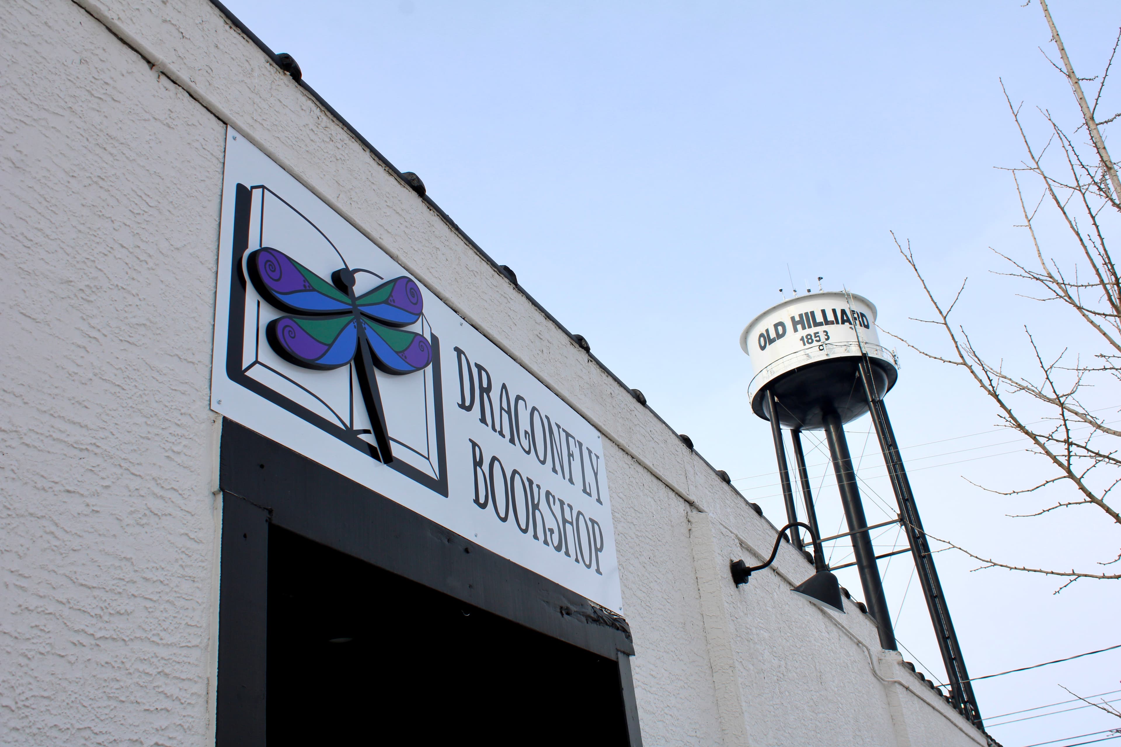 Dragonfly Bookshop storefront on Main Street in Hilliard, Ohio, with the shop sign and Old Hilliard water tower.
